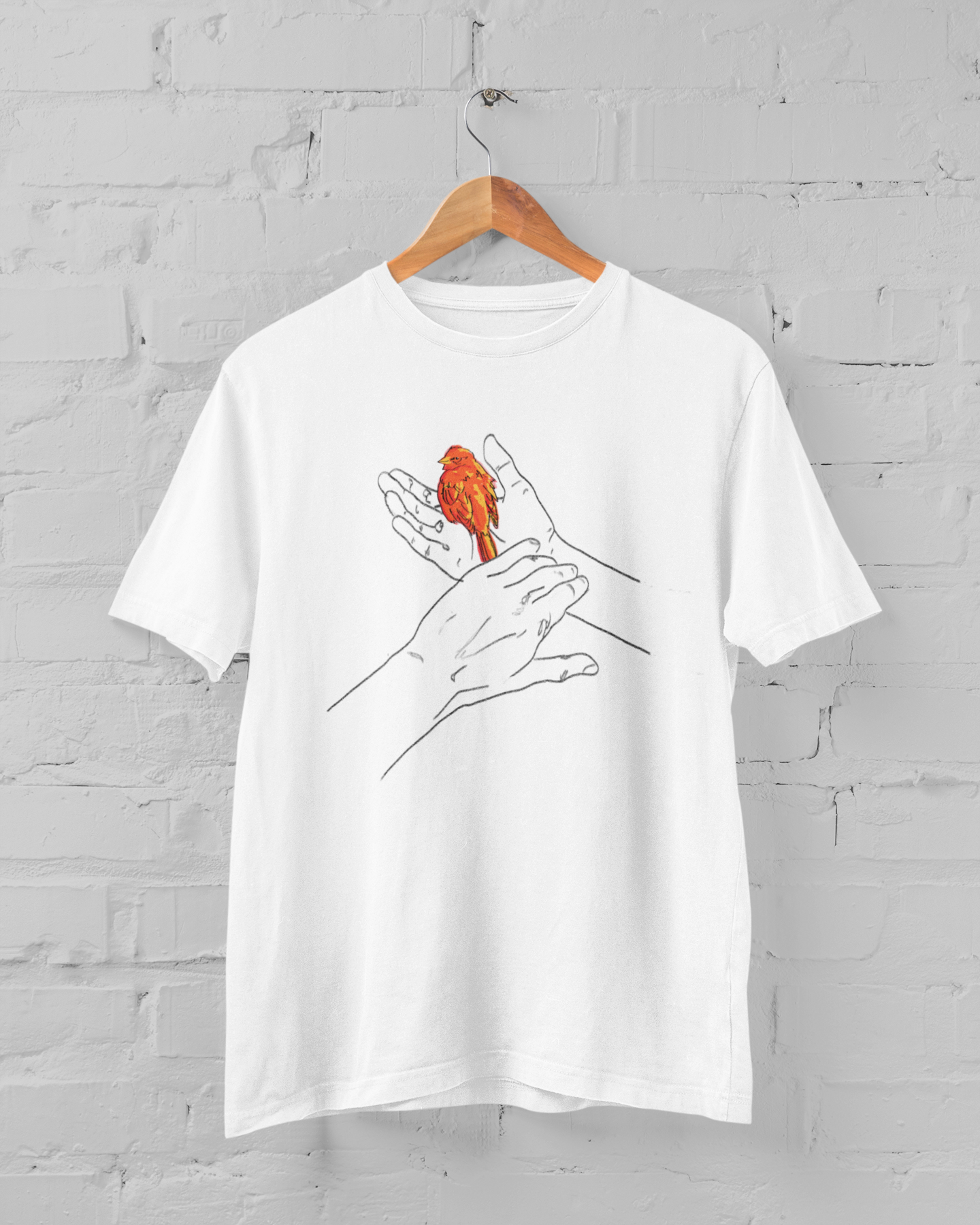 a white t shirt with grasp sparrows tail design on a hanger over a white brick backround