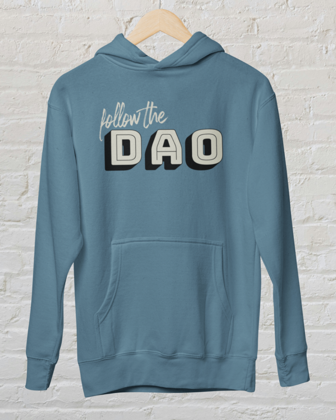 an Airforce blue hoodie with follow the dao design over a white brick backround