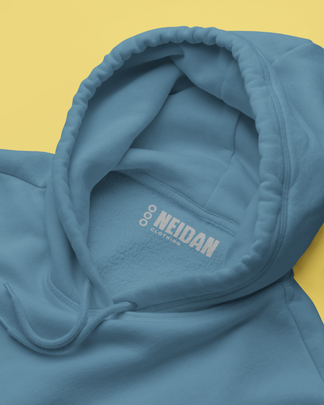 a closeup of an airforce blue hoodie neck label with neidan clothing logo