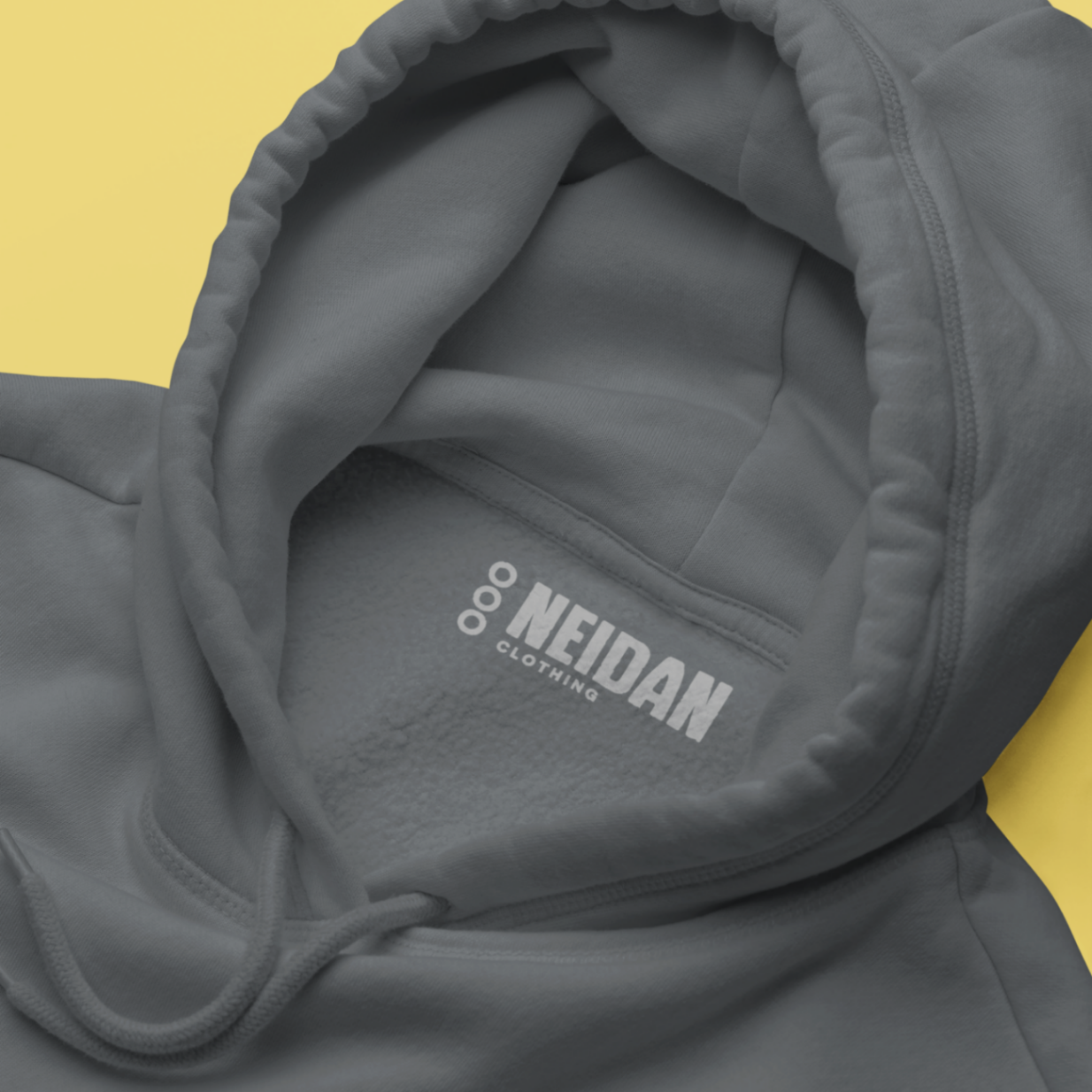 closeup of a steel grey hoodie neck label with the neidan clothing neck label