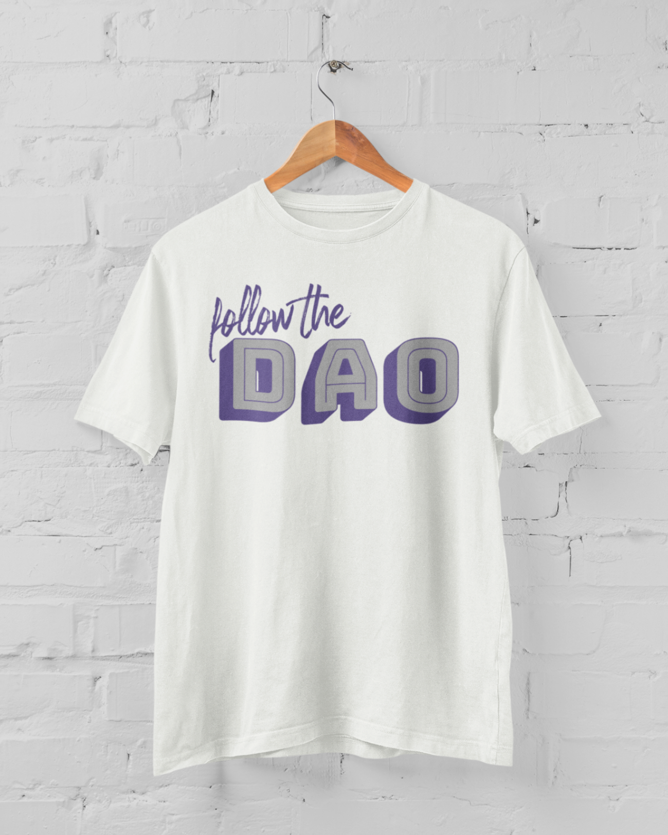 a white tshirt with purple and grey follow the Dao design on a hangar in front of a white brick backround