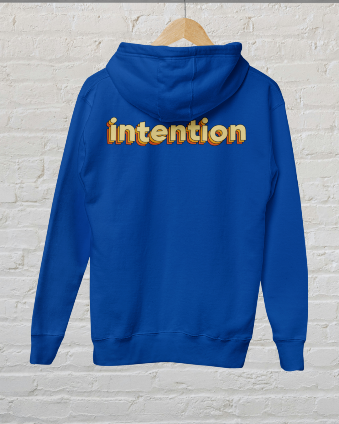 back view of a royal blue zip up hoodie with intention written in 3 D lettering across the upper back