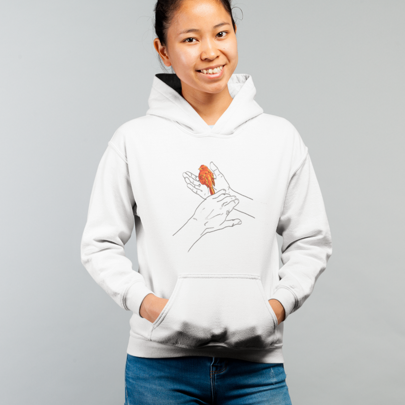 a female model smiling widely wearing a white hoodie with grasp sparrows design on front