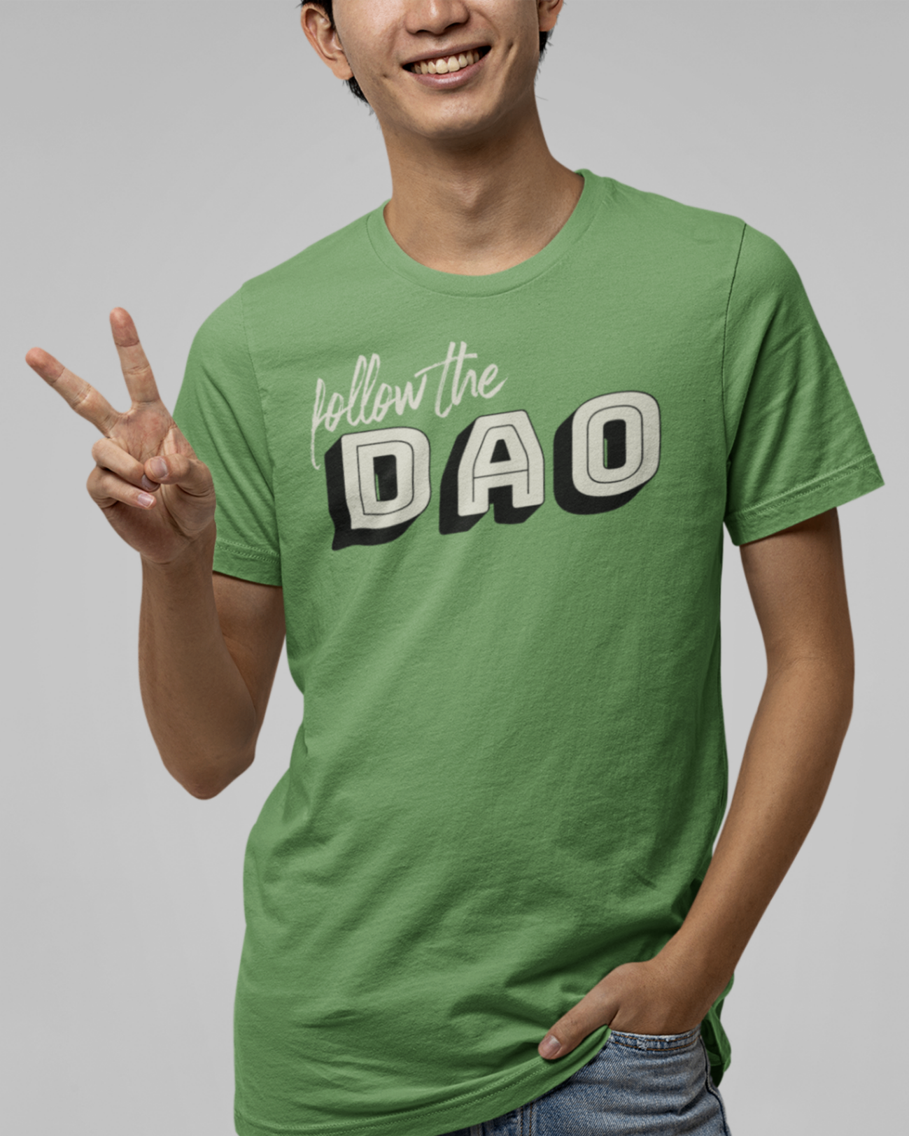 smiling man making the peace sign wearing a leaf coloured t shirt with follow the dao design