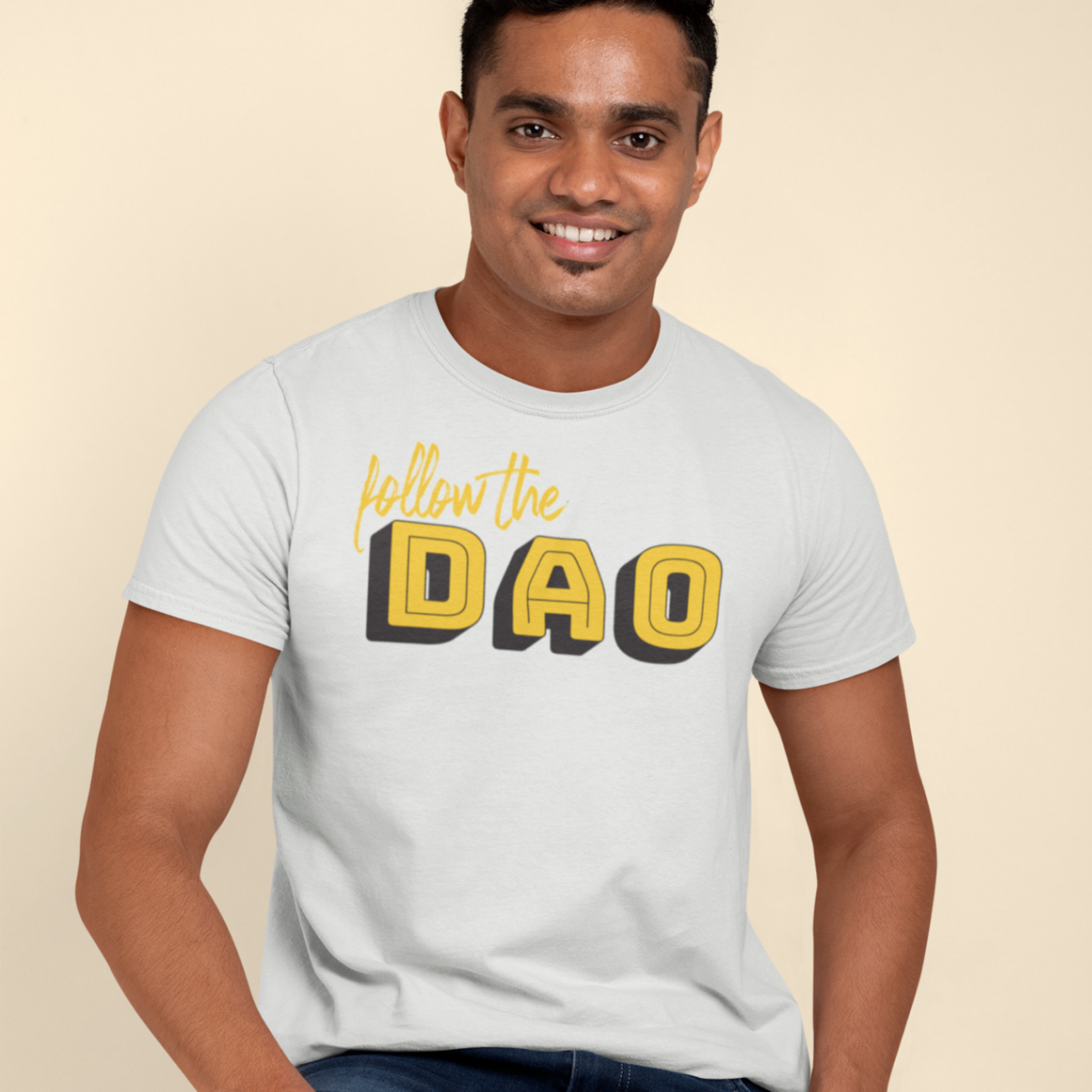 a calm man sitting wearing a white t shirt with follow the dao design in black and yellow