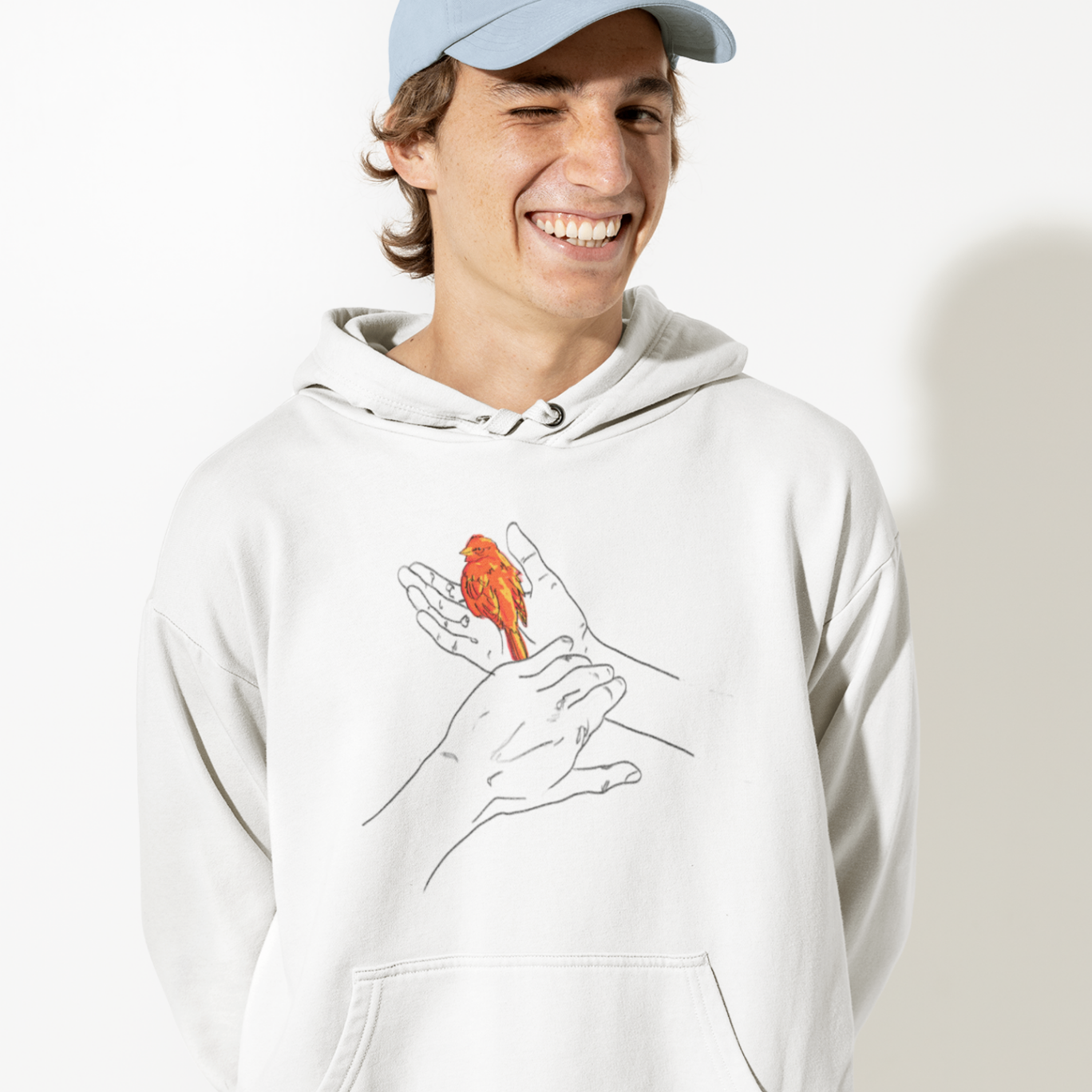 a male model smiling widely wearing a white hoodie with grasp sparrows design on front