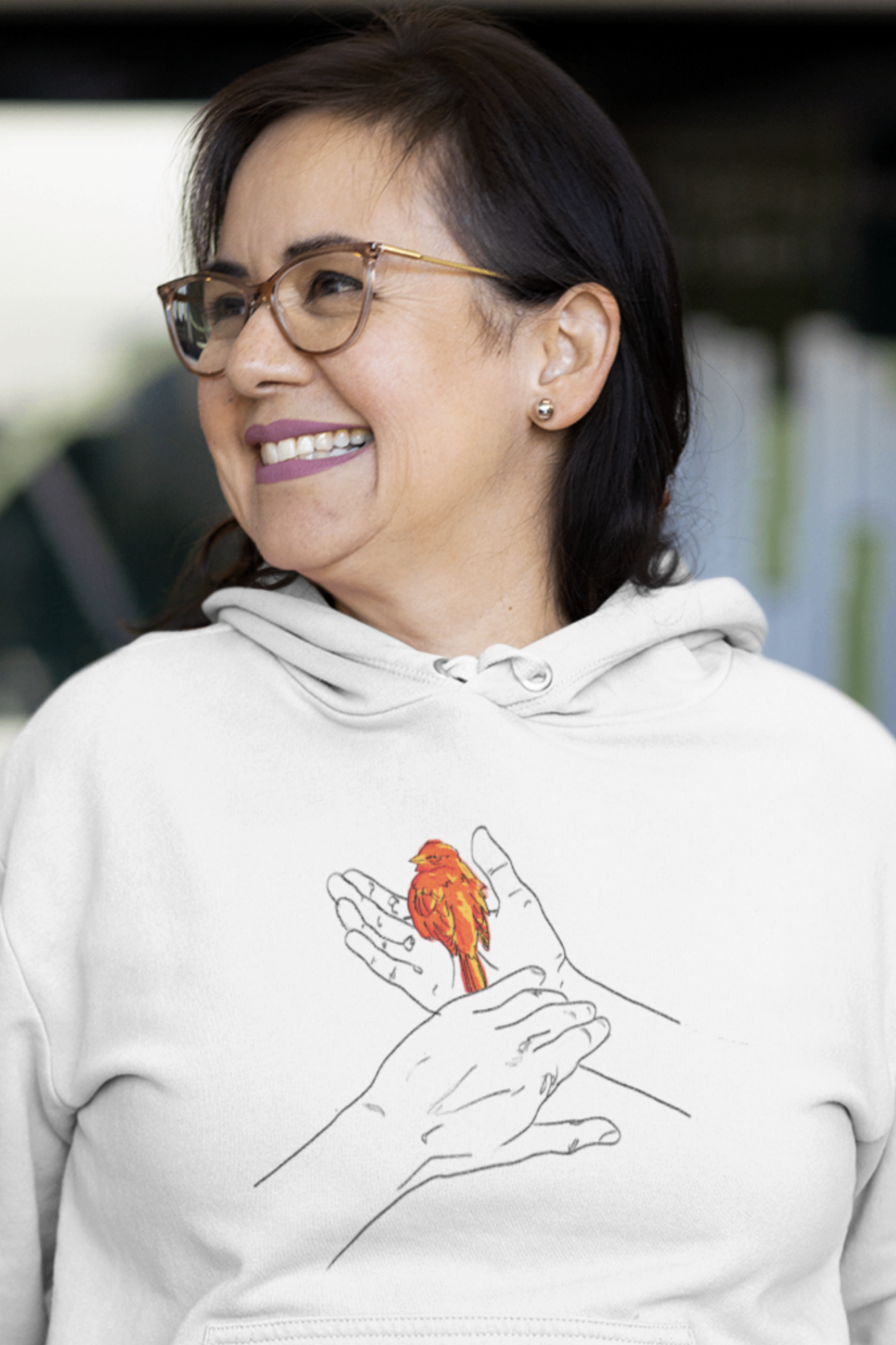 a happy woman wearing a white hoodie with grasp sparrows tail image on it