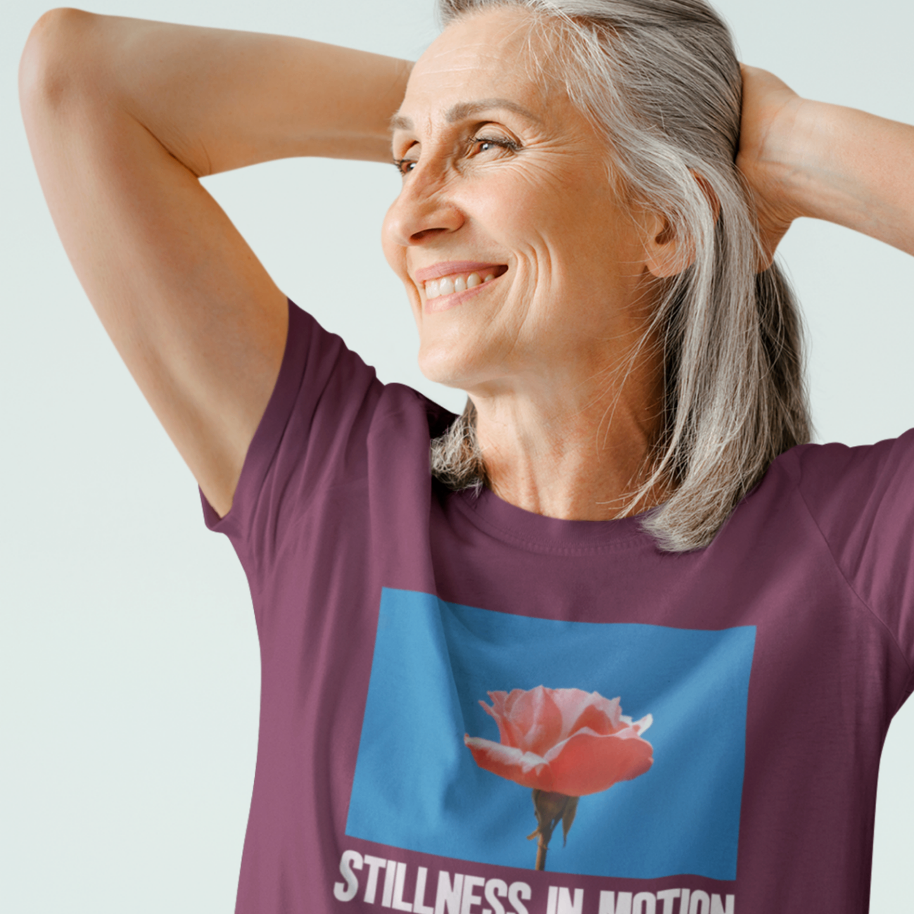 a cool middle aged woman wearing a maroon stillness in motion t shirt